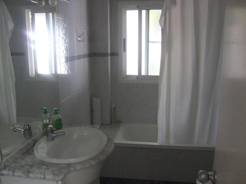 a bathroom with a sink and a tub and a shower at Can Juvimar in El Poblenou del Delta