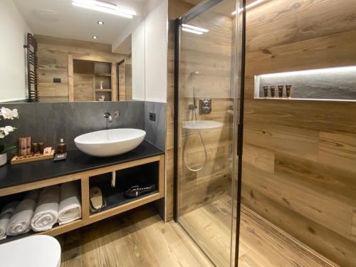 a bathroom with a glass shower and a sink at Sci Sport rooms & suites in Bormio