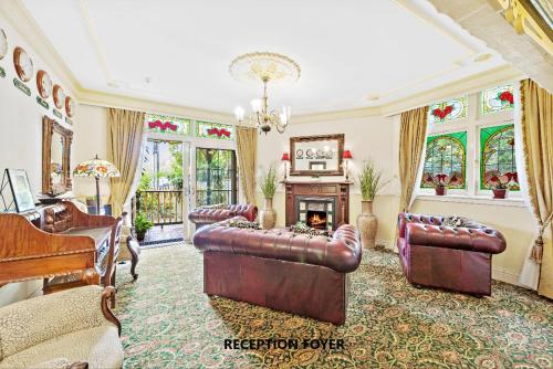 a living room with leather furniture and a piano at Charrington Hotel in Sydney