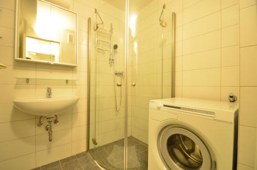 een badkamer met een wasmachine en een wastafel bij Ajo Vienna Siemens - Contactless Check-in in Wenen
