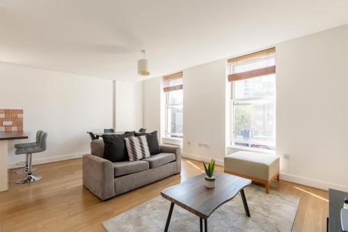 a living room with a couch and a table at Prime Location Flats in London