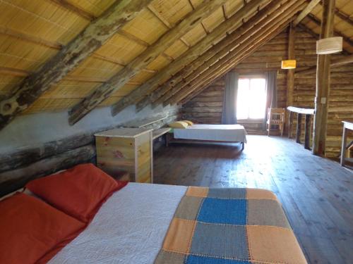 a bedroom in a log cabin with a bed and a window at Cabaña Navajuá in La Paloma