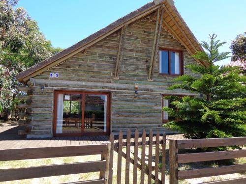 a log cabin with a wooden fence at Cabaña Navajuá in La Paloma