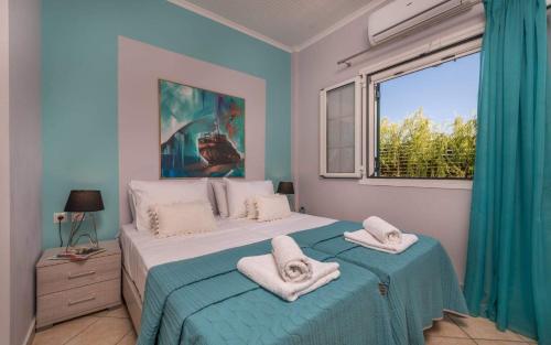 a bedroom with a bed with towels on it at Madini Luxury villa with private heated pool in Vanáton