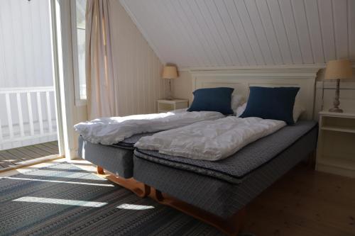 um quarto com uma cama grande e almofadas azuis em Holmsbu cabin 133 - cabin close to the sea em Asker