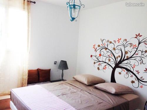 Villa SERENA في Sarrola-Carcopino: غرفة نوم مع شجرة مطبوعة على الحائط