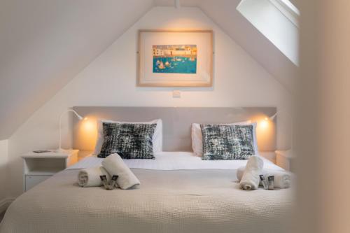 a bedroom with a white bed with two pillows at The Blue Door in Bath