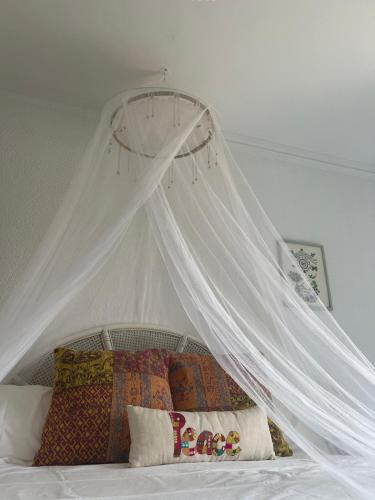 a white canopy over a bed with pillows at Ca Olivar in Teulada
