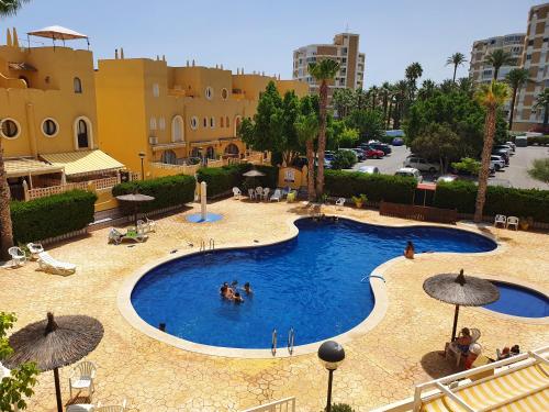 a large swimming pool with people in the water at Apartamento Alkabir Playa in El Campello