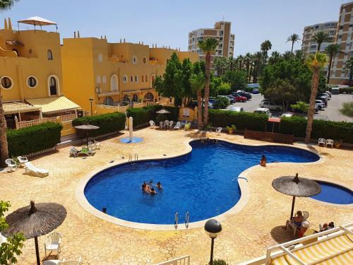 une grande piscine avec des gens dans l'eau dans l'établissement Apartamento Alkabir Playa, à El Campello