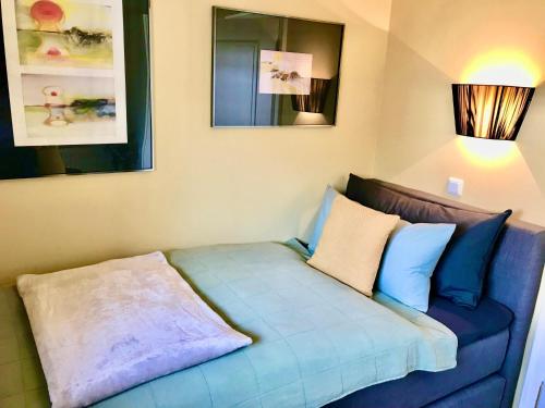 Un sofá azul con dos almohadas en una habitación en Hues-Stroongoedj-Haus-Strandgut en Westerland