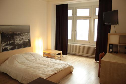 a bedroom with a bed and a large window at Le Relais in Düsseldorf