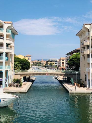 une rivière avec des bâtiments et un pont dans une ville dans l'établissement Charmant 2 pièces à Port-Fréjus, à Fréjus