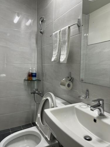 uma casa de banho com um lavatório, um WC e um espelho. em Bricks Stay Jeju City & Aiport em Jeju