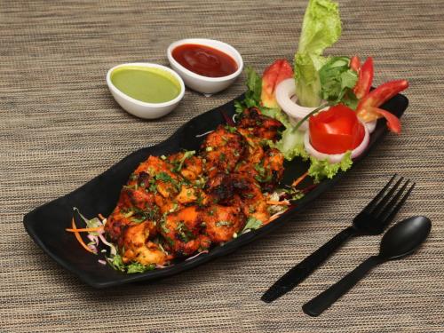 a plate of food on a table with a plate of food at The Grand Orion - Kailash Colony in New Delhi