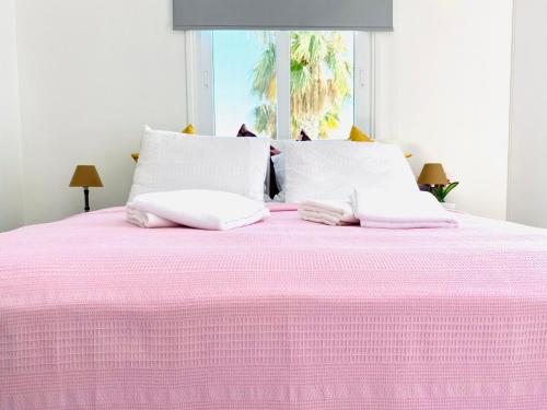 a pink bed with two white pillows on it at Exclusive Villa Larnaca - 8 plus sleeps - 2 min from BEACH - Big Private Pool in Pyla