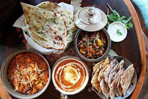 a table with many different types of food on it at The Grand Orion - Kailash Colony in New Delhi