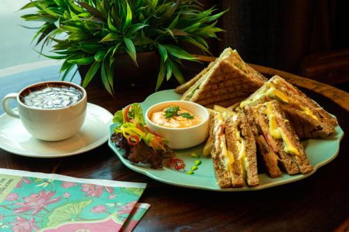 a plate with toast and a cup of coffee and a plate of soup at The Grand Orion - Kailash Colony in New Delhi