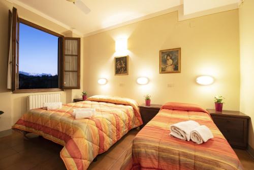 フィレンツェにあるフォレステリア ヴァルデーゼ ディ フィレンツェのベッドルーム1室(ベッド2台、タオル付)