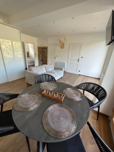 a living room with a table and chairs at Magnifique appartement classé 4 étoiles avec Sauna et terrasse dans chalet in La Bresse