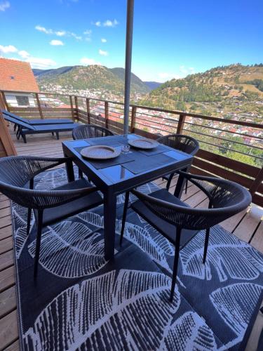 d'une table bleue et de chaises sur un balcon avec vue. dans l'établissement Magnifique appartement classé 4 étoiles avec Sauna et terrasse dans chalet, à La Bresse