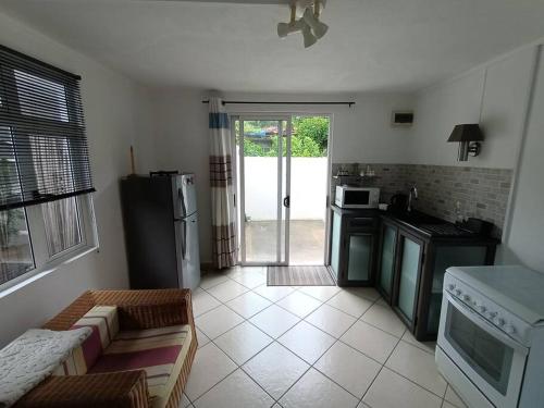 a kitchen with a refrigerator and a stove top oven at Surf house holidays in Baie du Cap