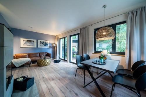 uma sala de estar com um sofá e uma mesa em Haus Schlehe -Domizil am Ostseewald em Zingst