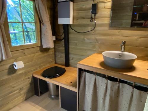 baño con lavabo en una encimera de madera en Le Dôme de Namur - Une nuit insolite dans les bois, en Champion