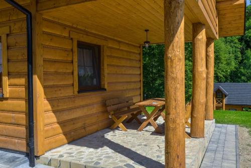 a wooden cabin with a picnic table on a patio at Niedźwiedzia Dolina in Przybyszów