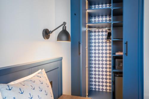 a bedroom with a blue door with a bed and a lamp at Hotel Yachtclub in Timmendorfer Strand