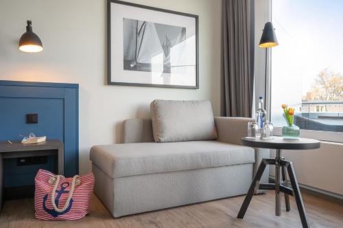 a living room with a chair and a table at Hotel Yachtclub in Timmendorfer Strand