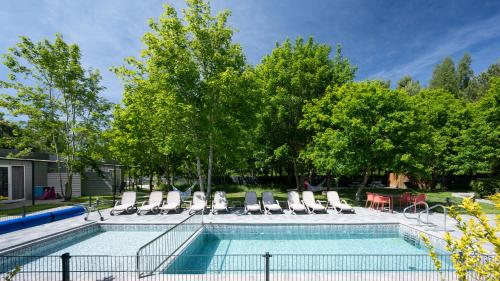 een zwembad met ligstoelen en een tafel bij MEDUSA apartamenty i bungalowy in Niechorze
