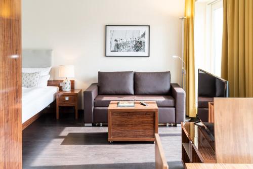 a living room with a couch and a bed at Hotel Yachtclub in Timmendorfer Strand
