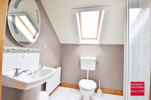 a bathroom with a sink and a toilet and a mirror at Sheelagh's Kitchen in Ballyferriter