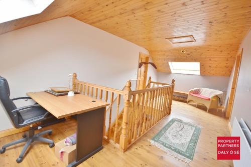 an attic office with a desk and a staircase at Sheelagh's Kitchen in Ballyferriter