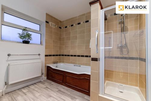 a bathroom with a tub and a sink and a shower at LONG STAYS 30pct OFF - Spacious 3 Bed with Parking & Keyless Access By Klarok Short Lets & Serviced Accommodation in Peterborough