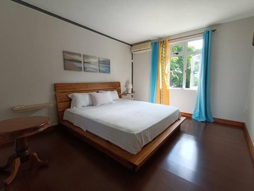 sypialnia z łóżkiem, stołem i oknem w obiekcie Surf house holidays w mieście Ruisseau Créole