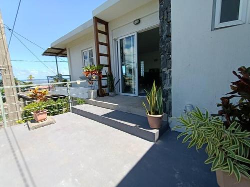 a house with potted plants on the front porch at Surf house holidays in Baie du Cap