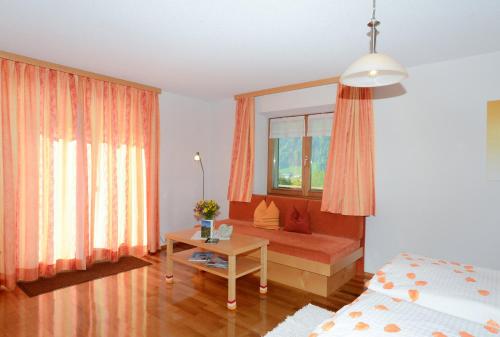 a bedroom with a bed and a table and a window at Fernblick Frühstückspension in Schoppernau