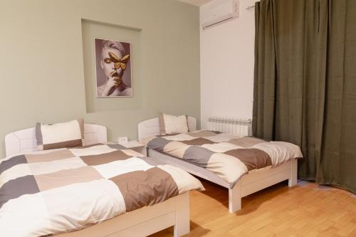 AirMi hotel في Surčin: سريرين يجلسون بجانب بعض في غرفة النوم