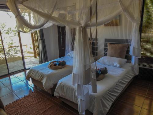 1 dormitorio con 2 camas con zapatos en Kaoko Mopane Lodge & Campsite, en Opuwo