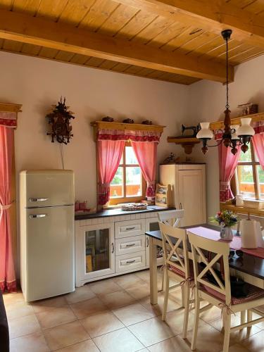 a kitchen with a refrigerator and a table with chairs at Chalupa na Leskové in Velké Karlovice