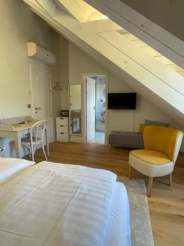 a bedroom with a bed and a table and a chair at Boutique Finca esencial Hotel Rural in Villafranca del Bierzo
