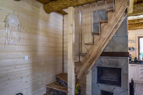a fireplace in a room with a wooden wall at Niedźwiedzia Dolina in Przybyszów