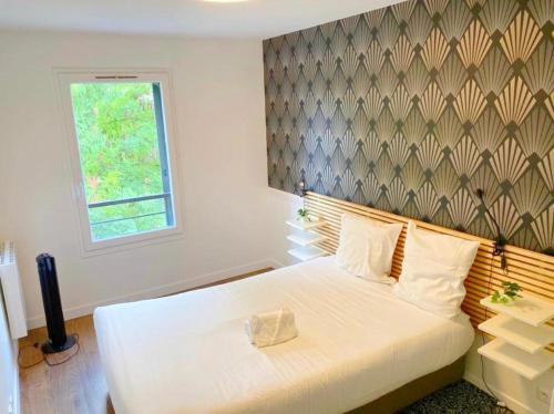 a bedroom with a large white bed with a window at FRUITIERS2 - Bright 3 BR 15' away from the center of Paris in Saint-Denis