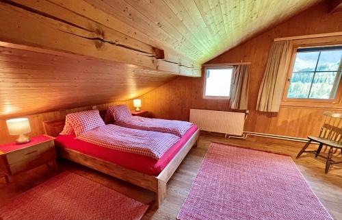 a bedroom with a bed and two red rugs at BnB Guesthouse Lusi in Frauenkirch