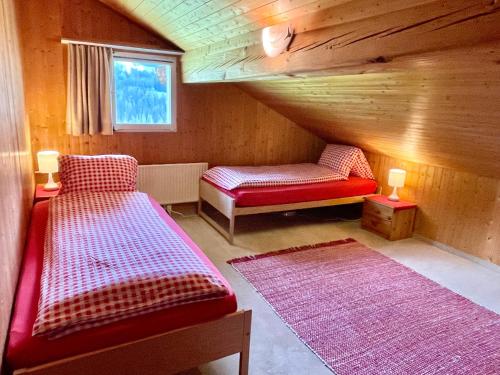 a attic room with two beds and a window at BnB Guesthouse Lusi in Frauenkirch