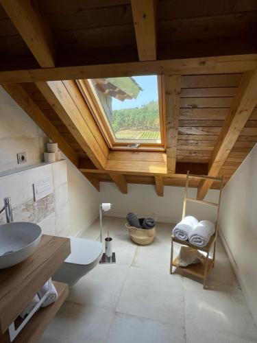 uma casa de banho com uma clarabóia e um lavatório em Hotel Boutique Finca esencial em Villafranca del Bierzo