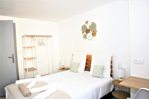 Habitación blanca con cama blanca y escritorio. en #Golden Dream's By Nogar'Homes -Wi-Fi-Netflix-Climatisation-Parking en Nogaro