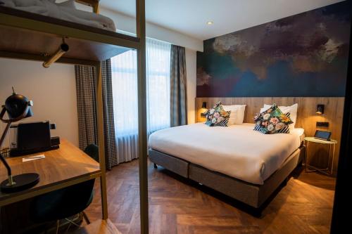a bedroom with a bed and a desk and a bunk bed at City Hotel Haarhuis, World Hotels Crafted Collection in Arnhem